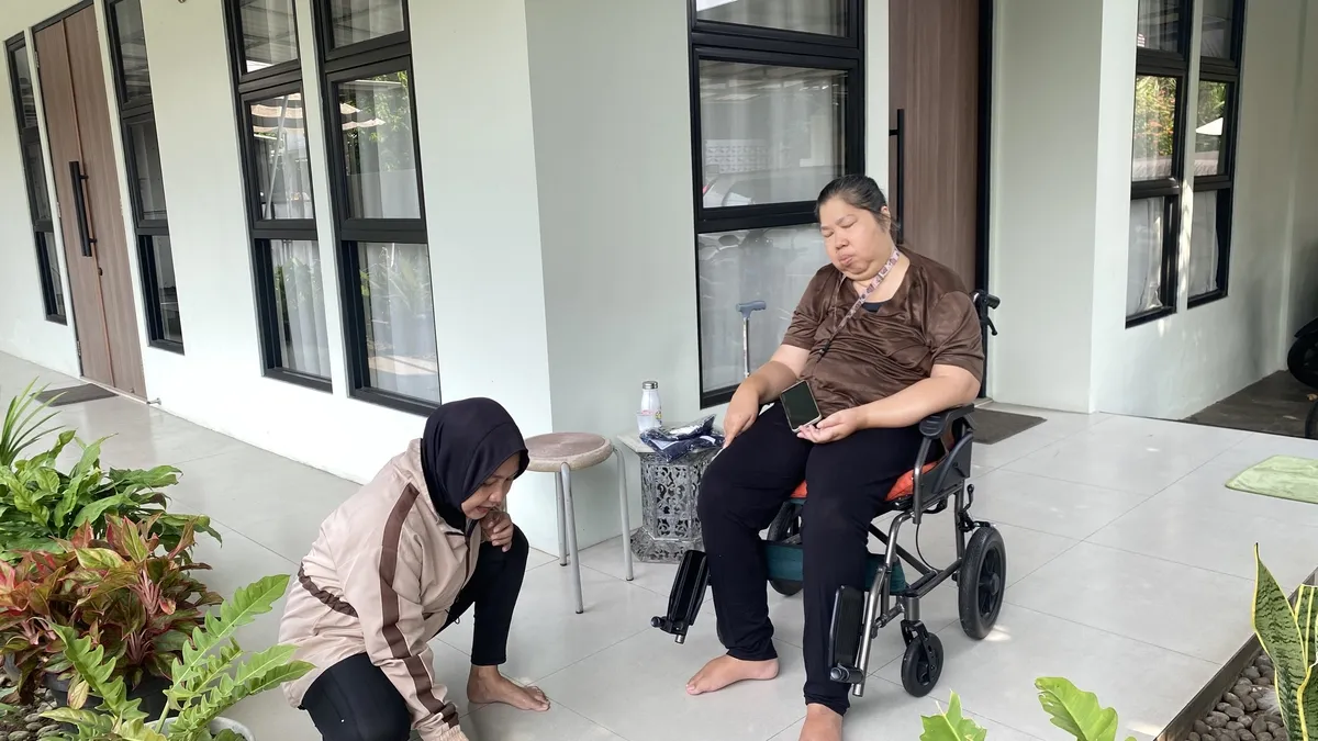 Personal trainer membimbing klien saat latihan menggunakan alat cable machine di gym